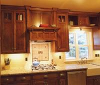 Thumb kitchen  craftsman style  quarter sawn oak  dark color  recessed panel doors  craftsman glass grid at the top  flush mount construction   13 bungalow crown  custom wood hood  apron front sink  upper above the window